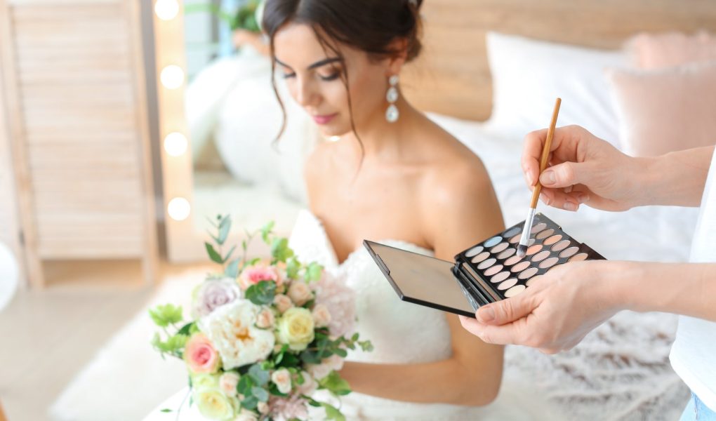 Maquilleuse professionnelle appliquant un maquillage naturel et lumineux sur une future mariée