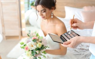 Maquilleuse professionnelle appliquant un maquillage naturel et lumineux sur une future mariée