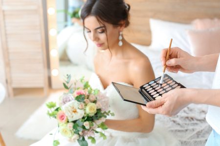 Maquilleuse professionnelle appliquant un maquillage naturel et lumineux sur une future mariée
