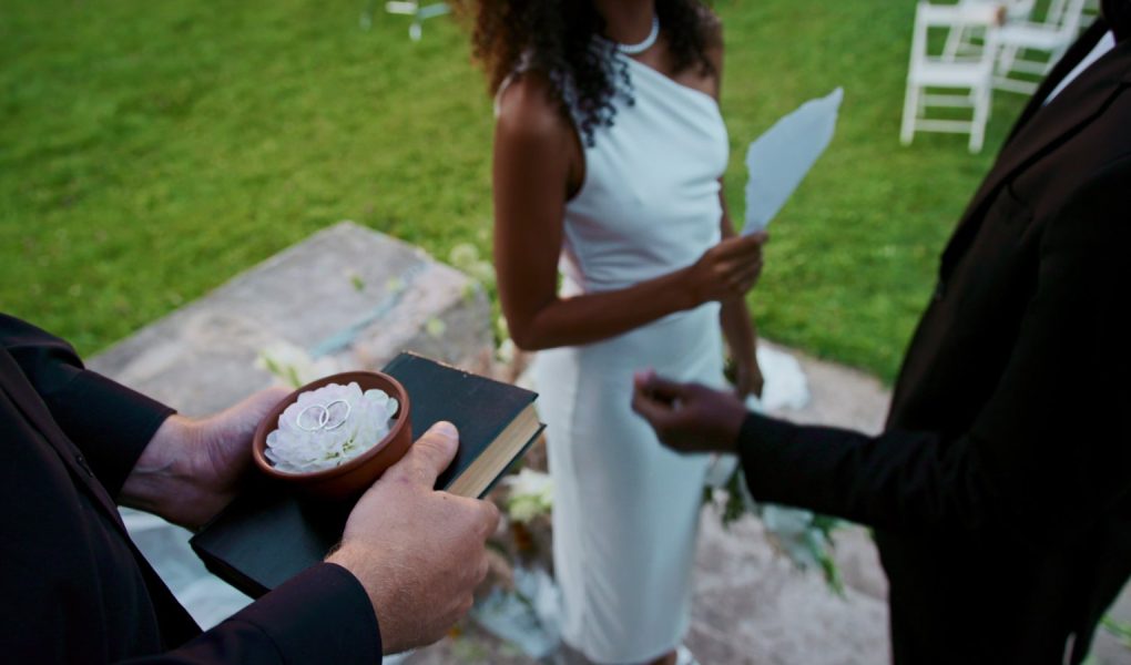 Mariée lisant ses vœux de mariage sur une feuille lors d'une cérémonie en plein air