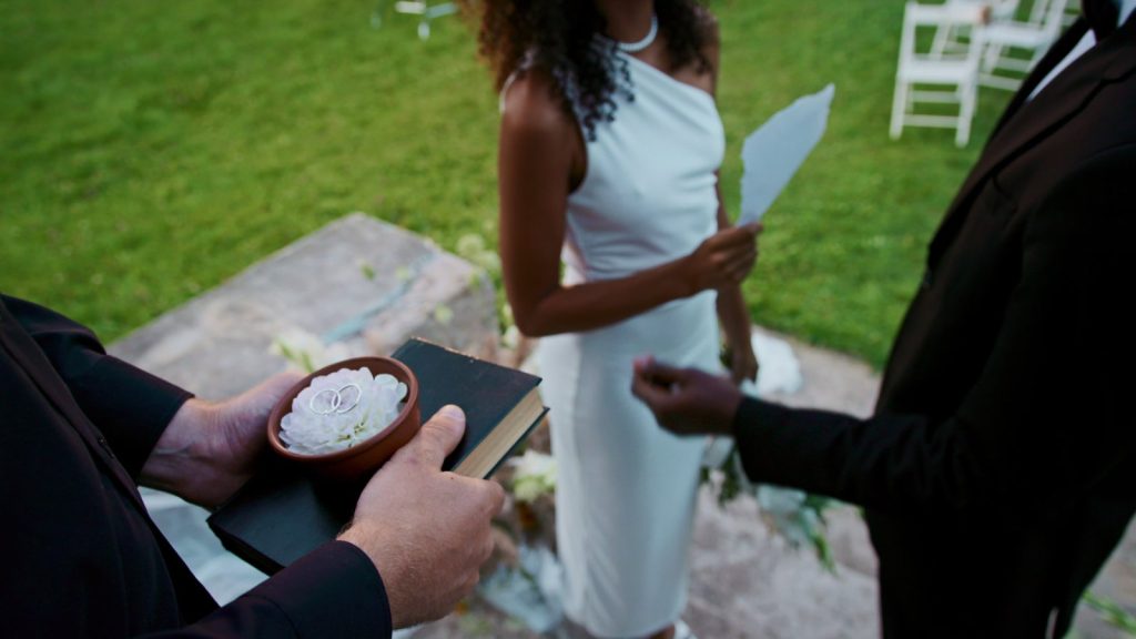 Mariée lisant ses vœux de mariage sur une feuille lors d'une cérémonie en plein air