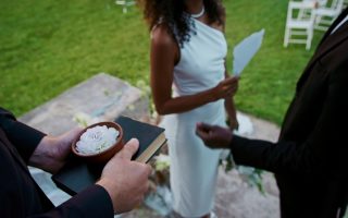 Mariée lisant ses vœux de mariage sur une feuille lors d'une cérémonie en plein air