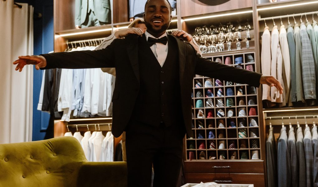 Futur marié souriant lors de l'essayage d'un costume dans une boutique de prêt-à-porter