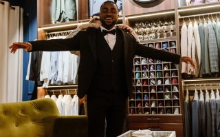Futur marié souriant lors de l'essayage d'un costume dans une boutique de prêt-à-porter