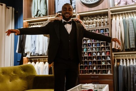 Futur marié souriant lors de l'essayage d'un costume dans une boutique de prêt-à-porter