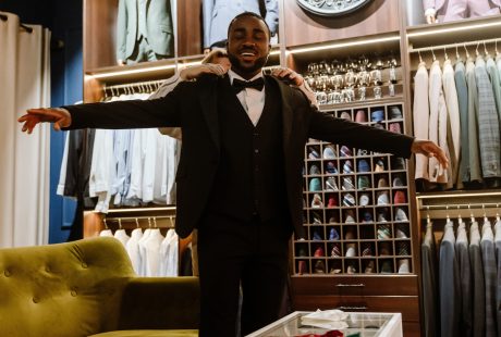 Futur marié souriant lors de l'essayage d'un costume dans une boutique de prêt-à-porter