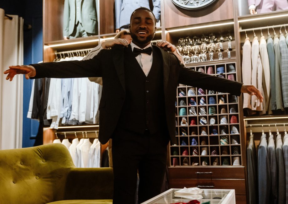 Futur marié souriant lors de l'essayage d'un costume dans une boutique de prêt-à-porter