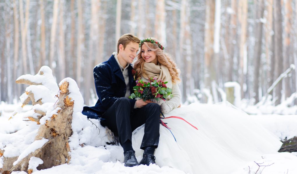 Couple de mariés souriants lors d'un mariage d'hiver en extérieur
