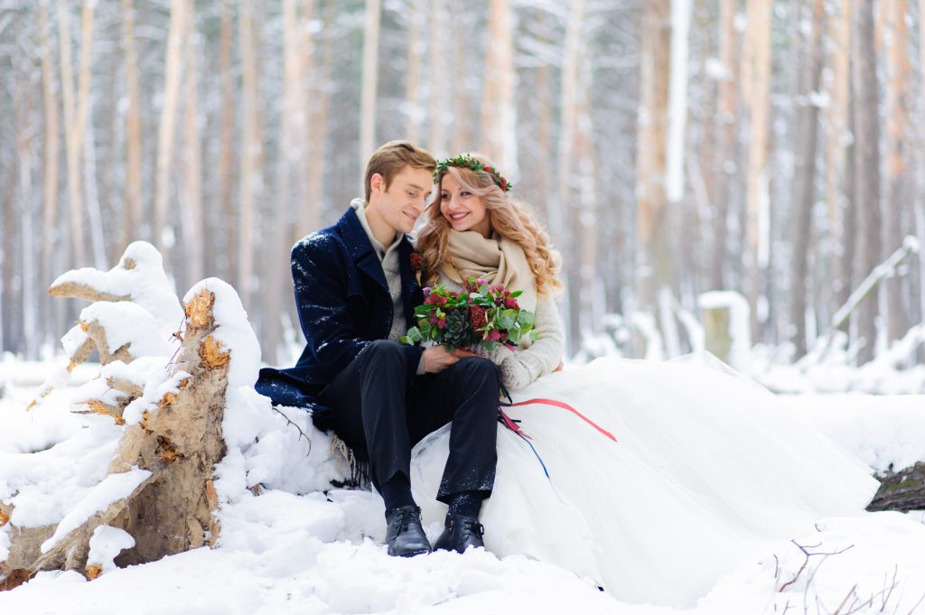 Couple de mariés souriants lors d'un mariage d'hiver en extérieur