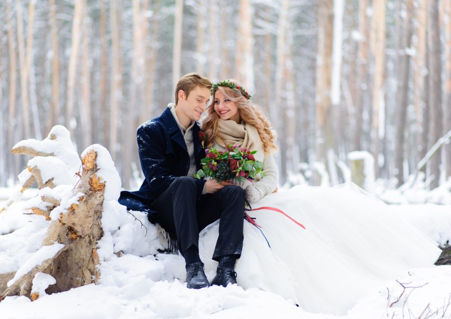 Couple de mariés souriants lors d'un mariage d'hiver en extérieur