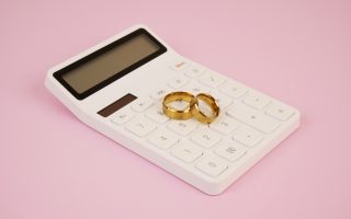 Alliances de mariage posées sur une calculatrice : budget et prix d'un mariage en Belgique