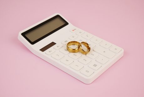 Alliances de mariage posées sur une calculatrice : budget et prix d'un mariage en Belgique