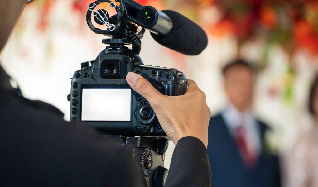 Vidéaste filmant la cérémonie d'un mariage avec une caméra équipée d'un micro