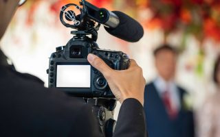 Vidéaste filmant la cérémonie d'un mariage avec une caméra équipée d'un micro