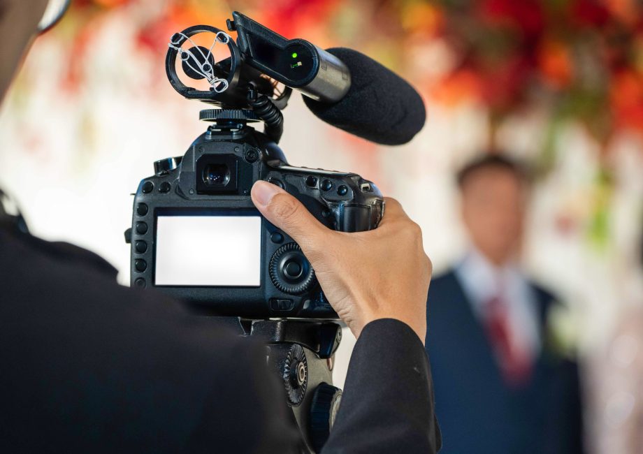 Vidéaste filmant la cérémonie d'un mariage avec une caméra équipée d'un micro