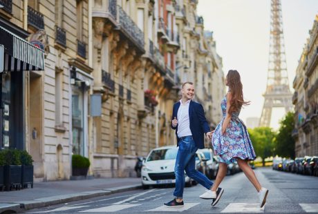 Couple traversant une rue parisienne avec la tour Eiffel en arrière-plan